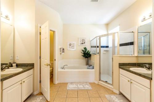 奥兰多基西米五卧室泳池度假屋的浴室配有两个盥洗盆和浴缸。
