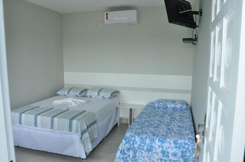莫雷蒂斯Pousada Guanumbi的一间小卧室,配有床和小长凳
