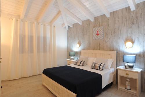 布多尼Residence SardegnaSummer Li Mori的一间卧室配有一张带2个床头柜和2盏灯的床。