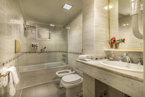 布宜诺斯艾利斯Up Viamonte Hotel的浴室配有卫生间、浴缸和水槽。