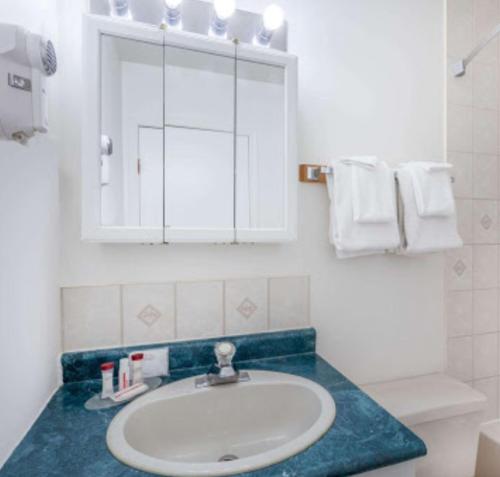 纳尔逊堡Almada Inn的浴室配有盥洗盆、镜子和毛巾