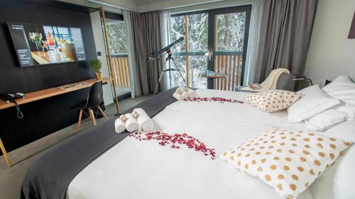Ličko Petrovo SeloLyra Hotel Plitvice的一间卧室配有一张白色大床,床上有鲜花