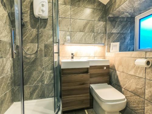 奥尔德姆Luxury traditional stone farmhouse in Saddleworth的带淋浴、卫生间和盥洗盆的浴室