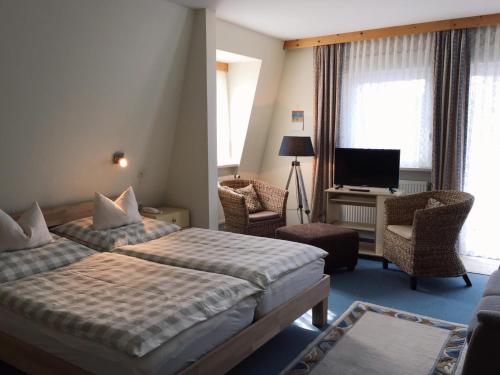 巴德斯特本Horn's Gästehaus的酒店客房设有两张床和电视。