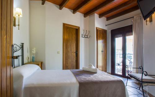 阿洛拉Hostal Valle Del Sol Alora的卧室配有白色的床和窗户。