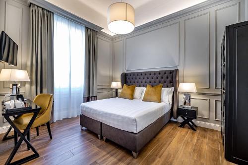 佛罗伦萨Hotel Ungherese Small Luxury Hotel的一间卧室配有一张床、一张桌子和一把椅子