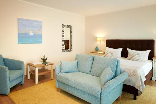 普特布斯诺迪鲁斯酒店的一间卧室配有一张床和两张蓝色椅子