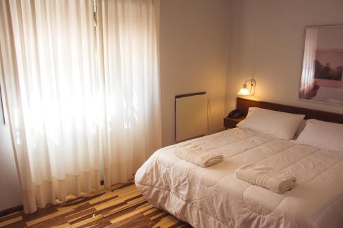 上格拉西亚Solares Hotel & Spa的一间卧室配有一张带白色床单的床和一扇窗户。