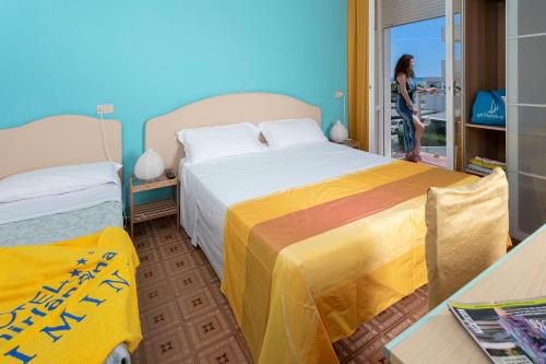 里米尼G House Rimini Spiaggia的一位妇女站在带两张床的房间