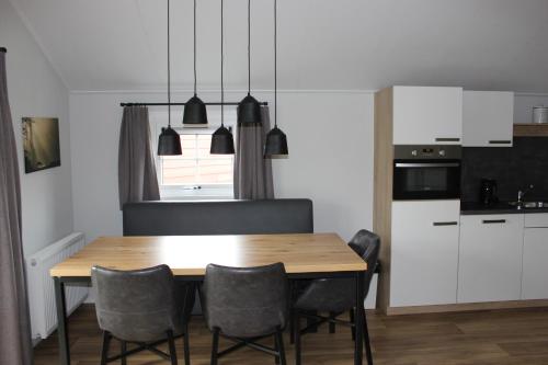 宁斯佩特De Bijsselse Enk, Noors chalet 4的厨房以及带木桌和椅子的用餐室。