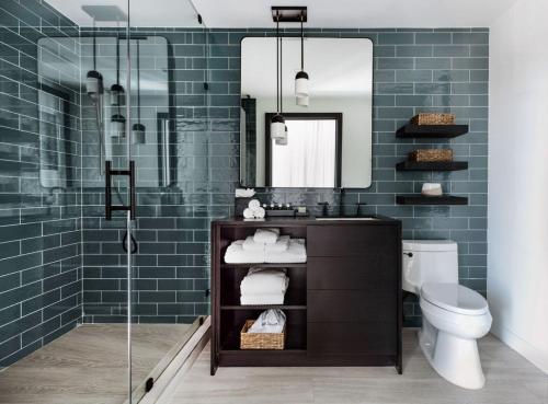 朗布兰奇Wave Resort的浴室设有水槽和蓝色瓷砖淋浴。