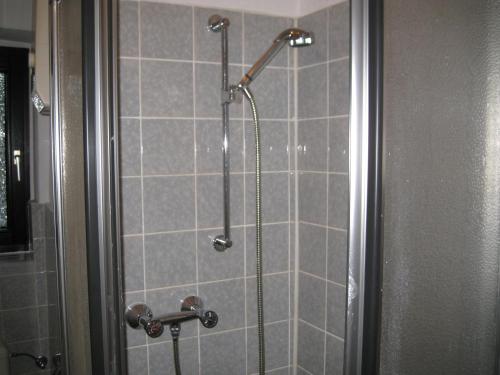 波鸿亚伯公寓的浴室铺有灰色瓷砖,设有淋浴。