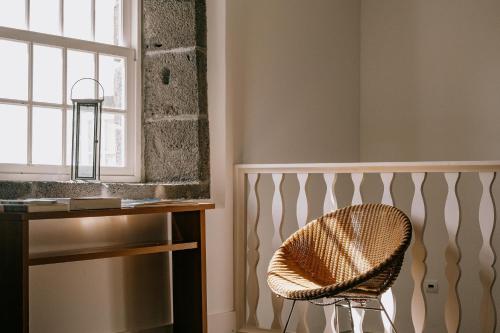 圣罗克杜皮库Azores Youth Hostels - Pico的一张椅子,位于带桌子和窗户的房间