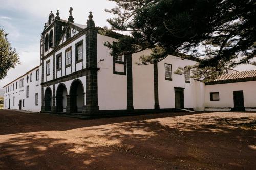 圣罗克杜皮库Azores Youth Hostels - Pico的前面有一棵树的白色大建筑