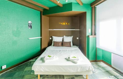 埃皮纳勒Chipote by Carl-Emilie的一间卧室设有一张大床和绿色的墙壁