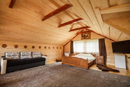 BeloberëzkaХата Різьбяра的小木屋内的卧室配有1张床和电视