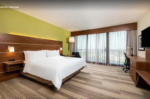 圣安娜Holiday Inn Express & Suites Santa Ana - Orange County, an IHG Hotel的酒店客房,配有床和电视