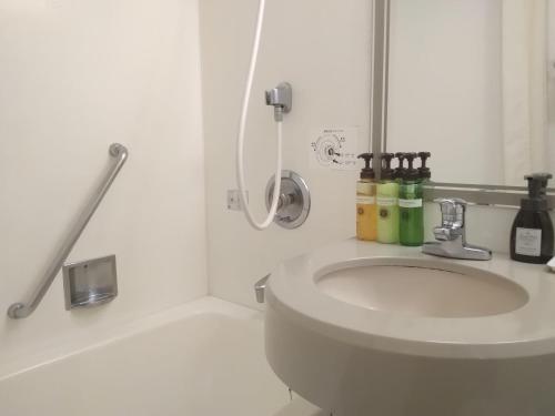 成田成田沃卡酒店的白色的浴室设有水槽和淋浴。
