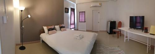 Ban Huai KapiPrinya house ปริญญา เฮ้าส์的卧室配有白色的床和电视。