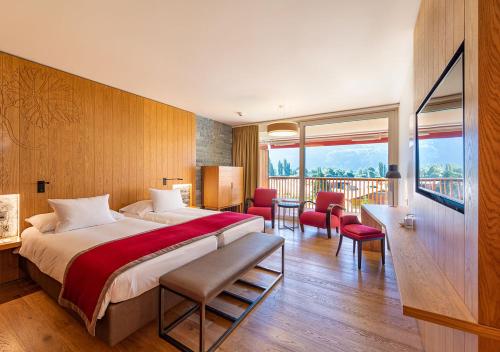 萨永Hôtel des Bains de Saillon的酒店客房设有一张大床和一个阳台。
