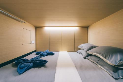 新加坡Wanderloft Capsule Hostel的一间卧室配有一张带蓝色枕头的大床
