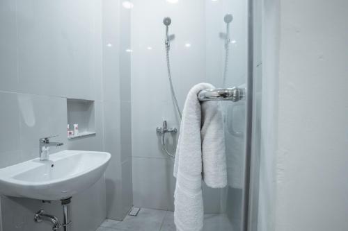 雅加达OYO 1487 Residence Khoe的白色的浴室设有水槽和淋浴。