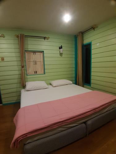 尖竹汶Baan Chan Sabai的一间卧室配有一张带粉色毯子的大床