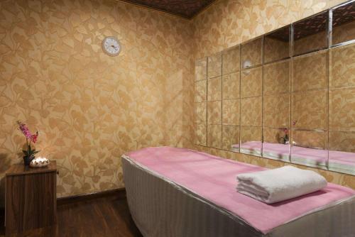 阿布扎比Howard Johnson by Wyndham Abu Dhabi Downtown的一间卧室配有一张带粉色床单和镜子的床
