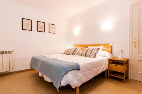 卡拉纳雅达Drac Blanc 1-3的卧室配有一张白色的大床和床头柜。