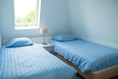 诺德韦克Bungalow 6p的带窗户的客房内的两张床