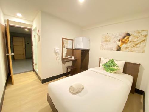芭堤雅市中心新星旅馆的卧室配有白色的床和帽子
