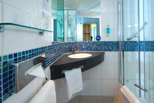 斯蒂夫尼奇快捷假日斯蒂夫尼奇酒店的一间带水槽和玻璃淋浴的浴室