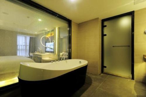贵阳麗枫酒店·贵阳花果园购物中心店的带浴缸和床的大型浴室