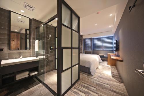 台中市逢甲微行商旅的浴室设有床、水槽和镜子