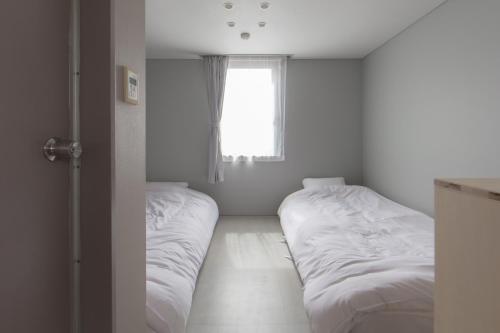 金泽Crasco TABI-NE的带窗户的客房内的两张床