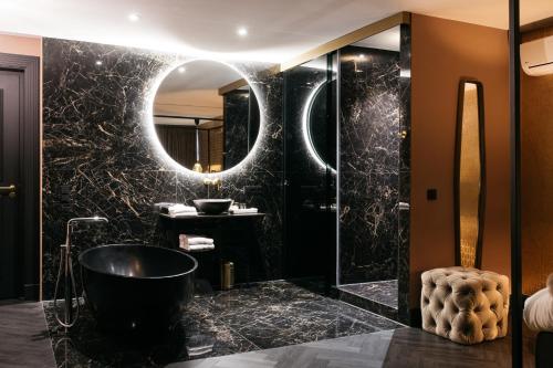 马斯特里赫特布雷藤尼克酒店的黑色浴室设有浴缸和镜子
