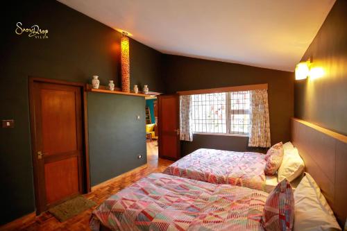 科代卡纳尔snow drop villa的一间卧室设有两张床和窗户。