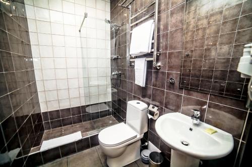 马格尼托哥尔斯克Business Hotel的一间带卫生间和水槽的浴室