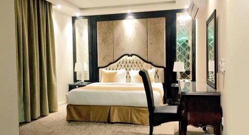 哈费尔巴廷Al Sharq Hotel的一间卧室配有一张大床、一张书桌和一张四柱床。