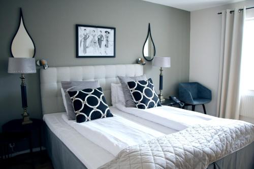 卡尔斯港Hotel Carlshamn的卧室配有白色大床和黑白色枕头