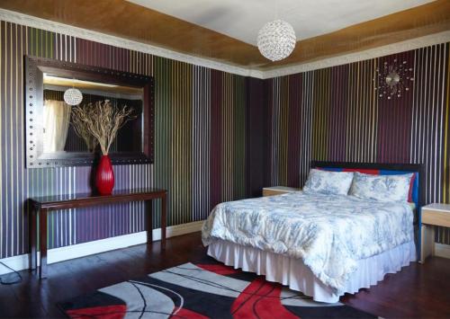 MatroosfonteinLiziwe's Guest House的卧室配有床和地毯上的花瓶
