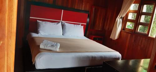 阿特利斯科Cabañas La Finca的一间卧室配有一张大床和红色床头板