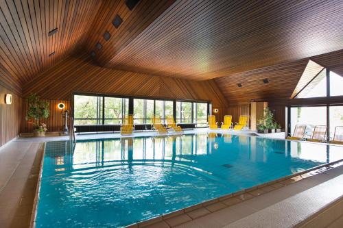 巴特拉尔豪斯格罗斯凯特勒酒店的一座大型游泳池,里面设有黄色椅子
