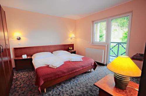 博德森特克欧丽米亚温泉罗萨公寓酒店的一间卧室配有床、灯和窗户