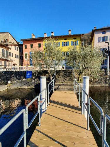 布鲁西诺亚希吉欧Dolceresio Lugano Lake B&B的一条木板路,横跨河流,有建筑