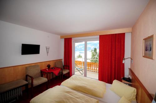 埃尔瓦尔德塔恩内霍夫酒店的一间卧室设有一张床和一个阳台的窗户。