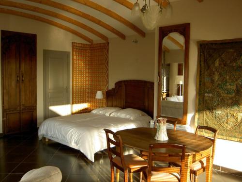 卡尚杜可多酒店的一间卧室配有一张床、一张桌子和一面镜子