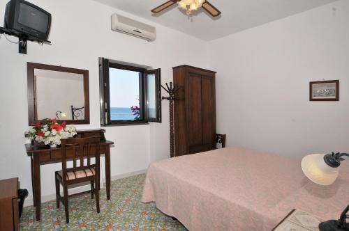 斯特龙博利Hotel Villaggio Stromboli - isola di Stromboli的一间卧室配有一张床、一张桌子和一面镜子