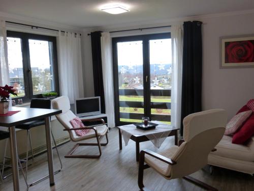 马尔梅迪地平线公寓酒店的客厅配有桌椅和窗户。