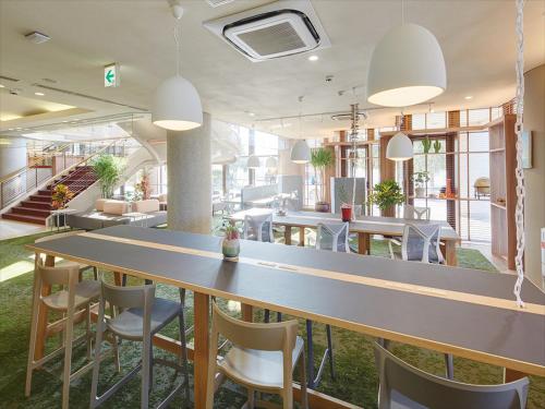 名户冲绳余家弗酒店的大型用餐室配有大桌子和椅子
